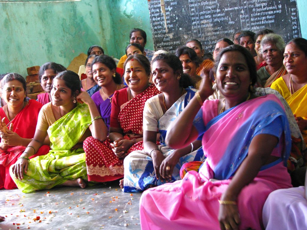 Group of women in India, sitting and smiling