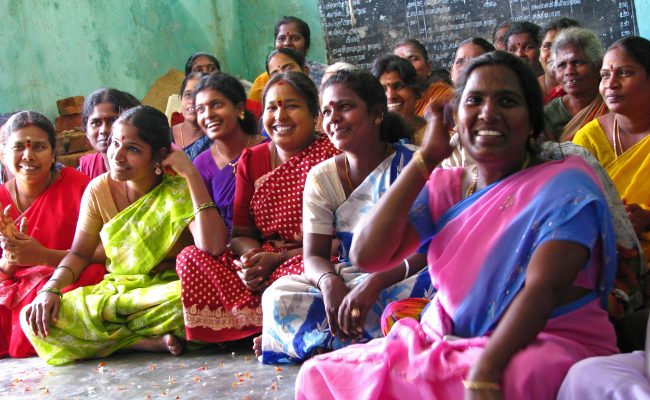 Group of women in India, sitting and smiling