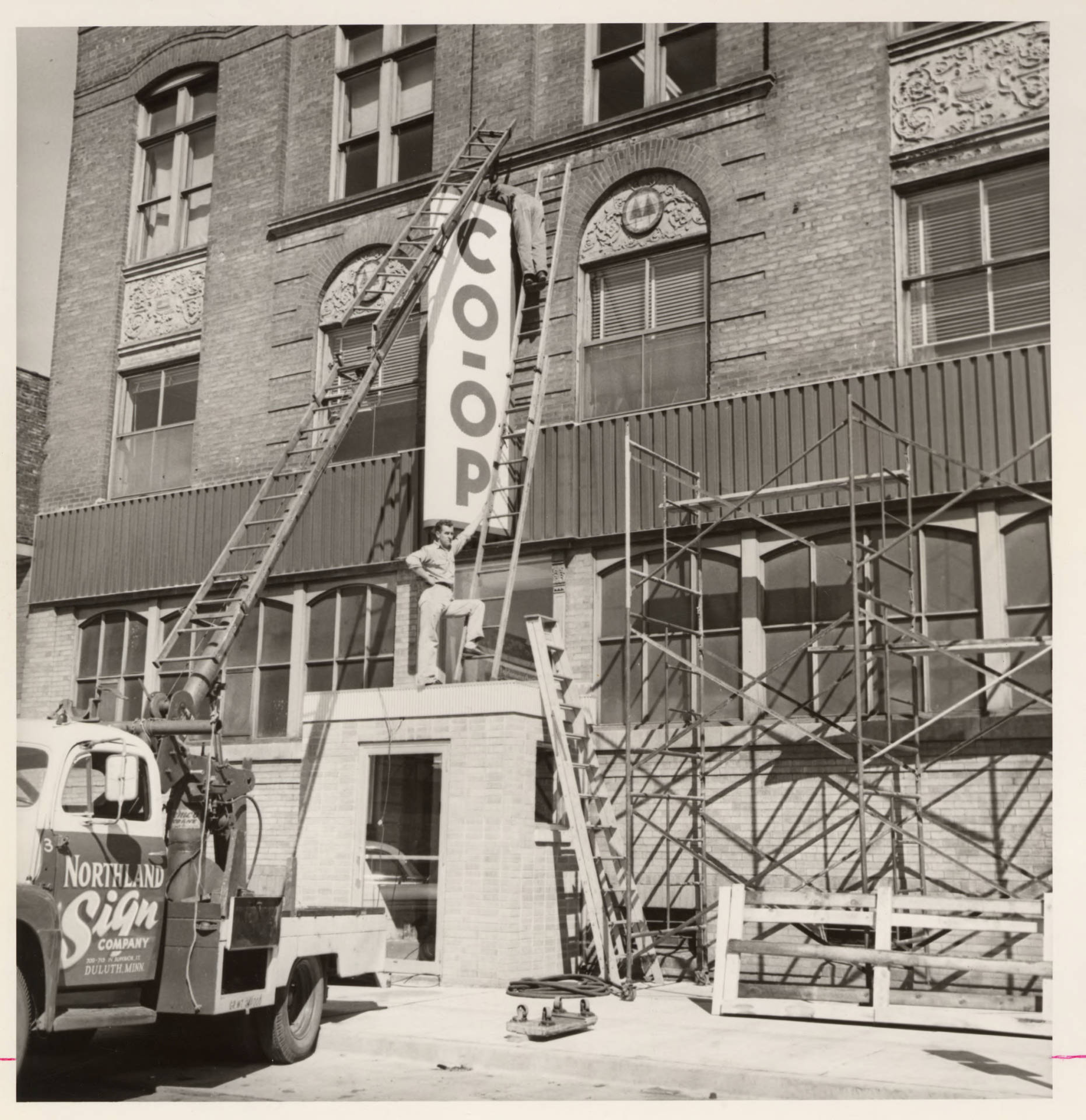 Installing new signs, Central Cooperative Wholesale Records, im111739, Box 40, IHRCA426, Immigration History Research Center Archives, University of Minnesota.